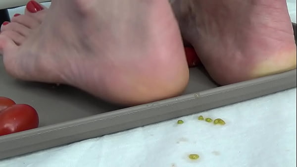 Garota pisa tomates com os pés enquanto se masturba